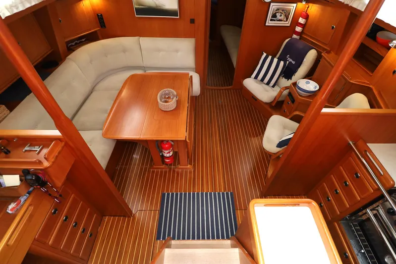 Cygnus Yacht Photos Pics Interior of 2000 Hallberg-Rassy 46 yacht with wooden flooring and cozy seating area.