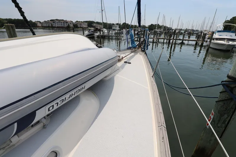 Cygnus Yacht Photos Pics Hallberg-Rassy 46 sailboat deck with dinghy, docked in a marina, 2000 model.
