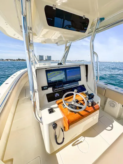 Full Attention Yacht Photos Pics 2012 Contender 39 ST boat helm with dual screens and steering wheel on open water.