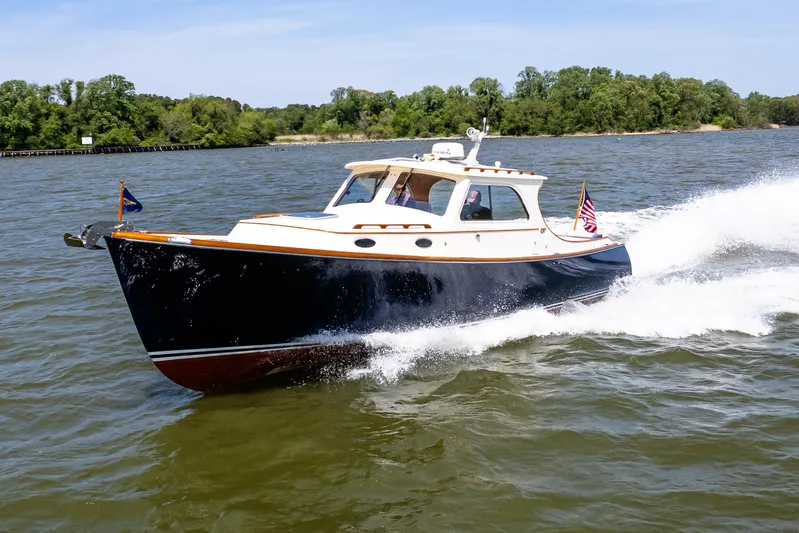Old Fashioned Yacht Photos Pics 2002 Hinckley Picnic Boat EP cruising on a scenic river with lush green trees.