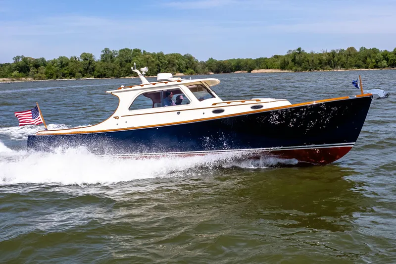 Old Fashioned Yacht Photos Pics 2002 Hinckley Picnic Boat EP cruising on a lake with American flag.