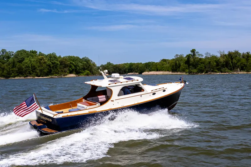 Old Fashioned Yacht Photos Pics 2002 Hinckley Picnic Boat EP cruising on a scenic waterway with lush green shoreline.