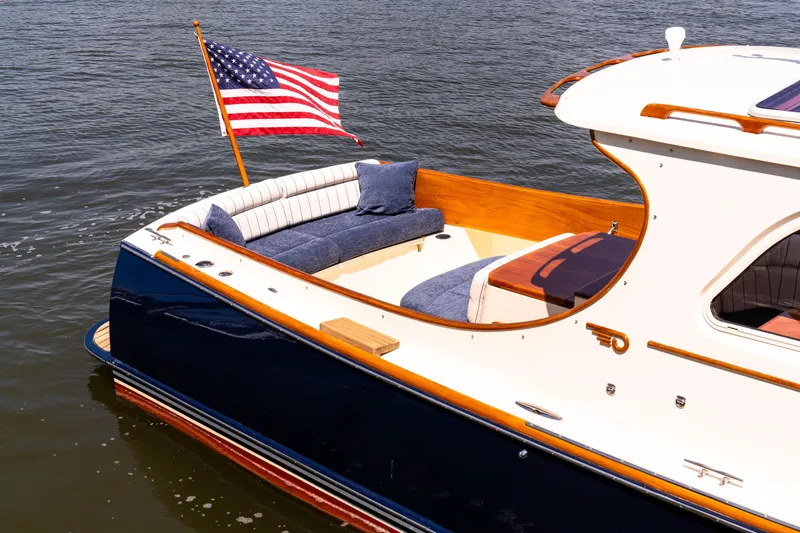 Old Fashioned Yacht Photos Pics 2002 Hinckley Picnic Boat EP with American flag, elegant seating, and classic design on the water.
