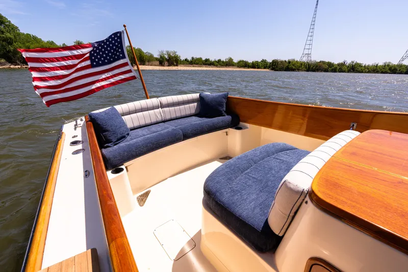Old Fashioned Yacht Photos Pics 2002 Hinckley Picnic Boat EP with American flag, featuring elegant seating on calm waters.