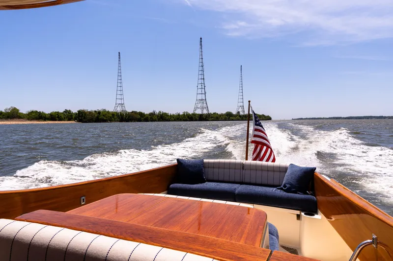 Old Fashioned Yacht Photos Pics 2002 Hinckley Picnic Boat EP cruising on open water with American flag.