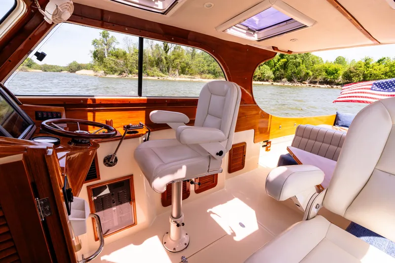 Old Fashioned Yacht Photos Pics 2002 Hinckley Picnic Boat EP interior with white seating, wooden accents, and river view.