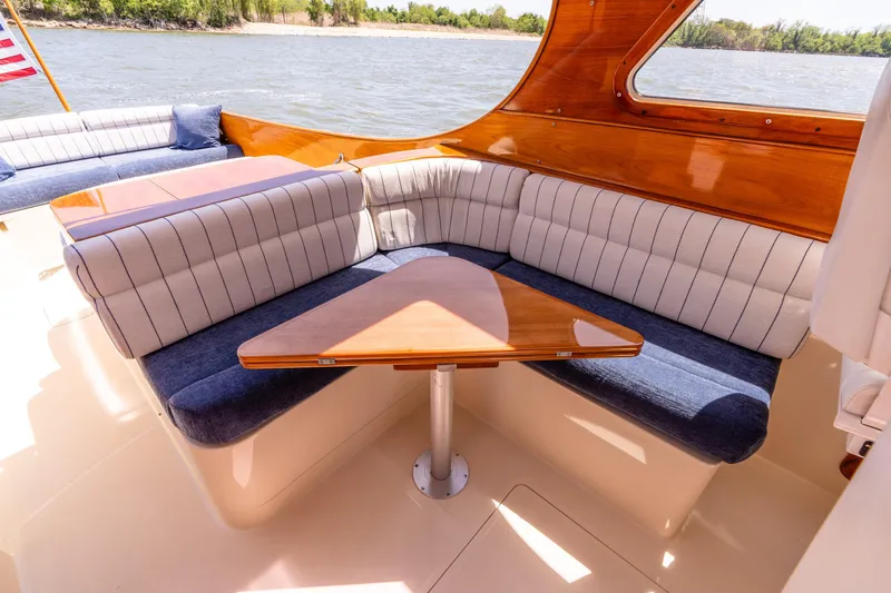 Old Fashioned Yacht Photos Pics 2002 Hinckley Picnic Boat EP interior with elegant seating and wooden table by the water.