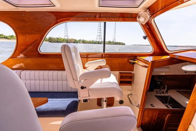 Old Fashioned Yacht Photos Pics 2002 Hinckley Picnic Boat EP interior with plush seating and wood finish, overlooking serene waters.