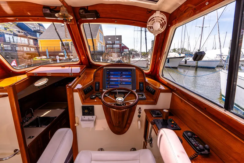 Old Fashioned Yacht Photos Pics 2002 Hinckley Picnic Boat EP interior with wooden dashboard and marina view.