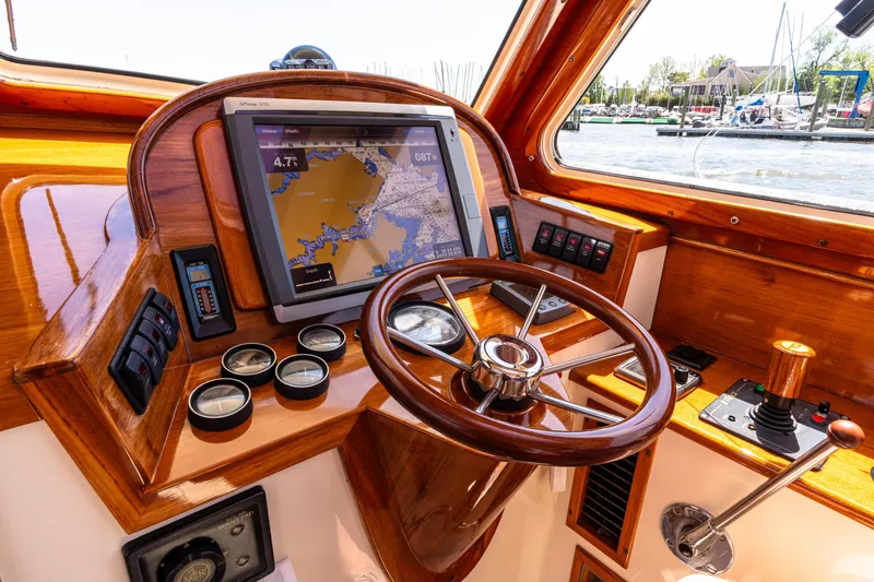Old Fashioned Yacht Photos Pics 2002 Hinckley Picnic Boat EP helm with navigation screen and wooden steering wheel.