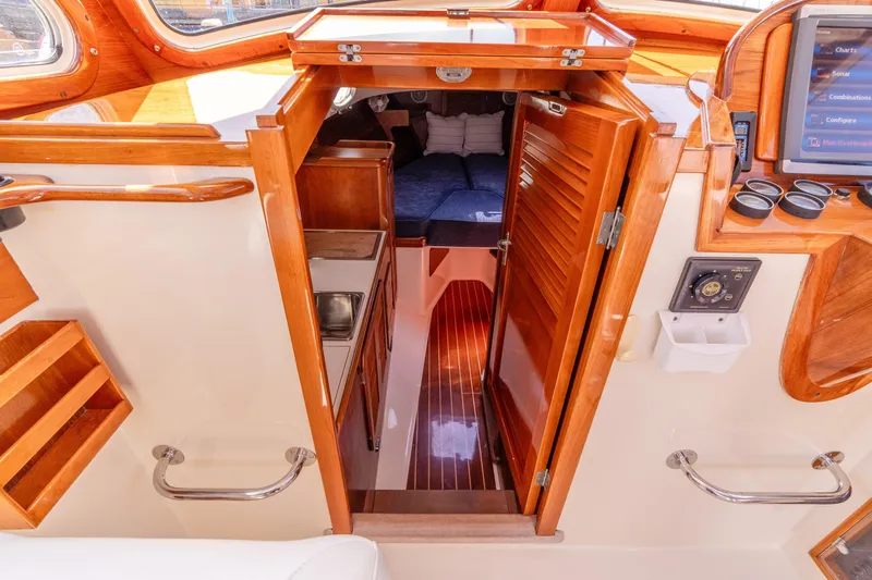 Old Fashioned Yacht Photos Pics Interior view of 2002 Hinckley Picnic Boat EP, featuring wooden finishes and cozy cabin space.