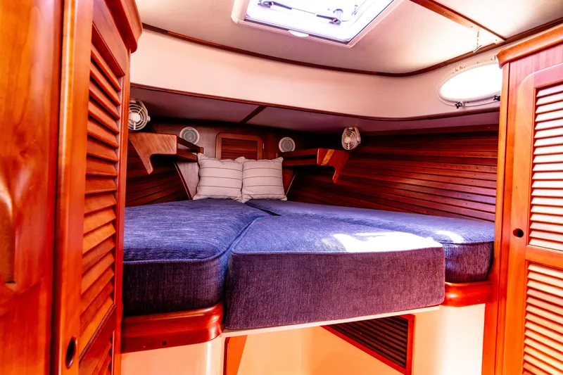 Old Fashioned Yacht Photos Pics 2002 Hinckley Picnic Boat EP cabin with wooden interior and cozy bedding.