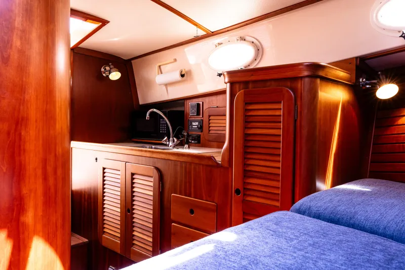 Old Fashioned Yacht Photos Pics 2002 Hinckley Picnic Boat EP interior with wooden cabinetry and cozy seating area.