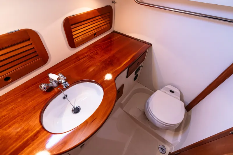 Old Fashioned Yacht Photos Pics 2002 Hinckley Picnic Boat EP bathroom with wooden countertop, sink, and toilet.