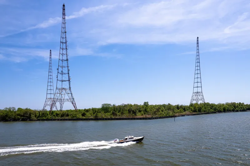 Old Fashioned Yacht Photos Pics A 2002 Hinckley Picnic Boat EP cruising near tall radio towers on a sunny day.