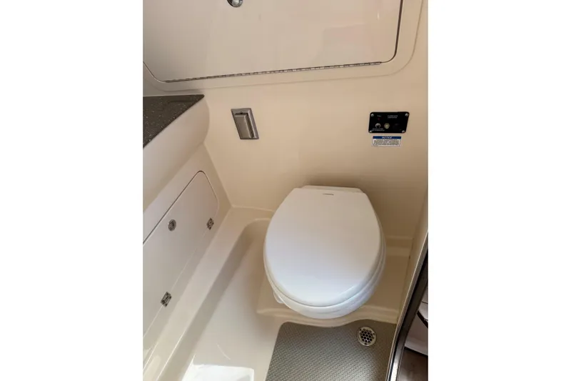  Yacht Photos Pics 2019 Boston Whaler 315 Conquest boat bathroom with toilet and storage compartments.