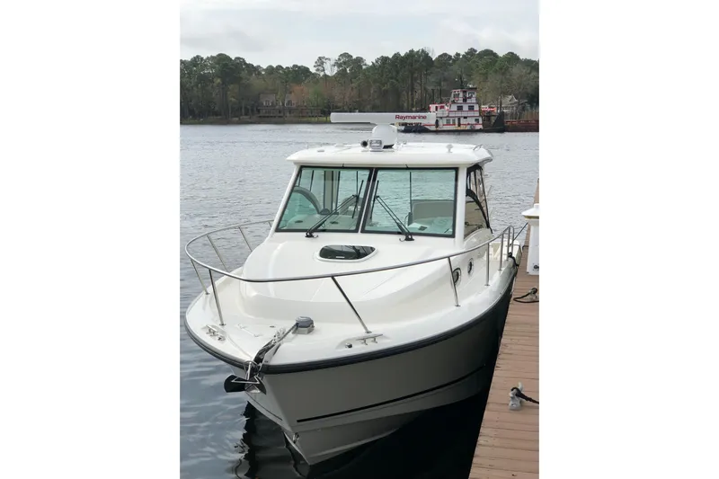  Yacht Photos Pics 2019 Boston Whaler 315 Conquest docked on a calm lake.