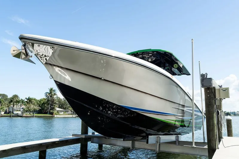  Yacht Photos Pics 2022 Fountain 34 SC boat on lift, docked by waterfront homes.