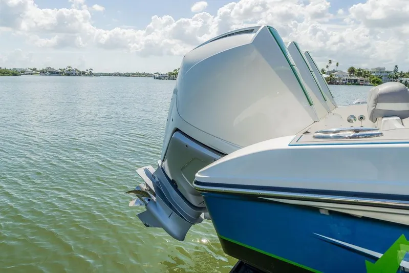  Yacht Photos Pics 2022 Fountain 34 SC boat with powerful outboard engines on a serene lake.