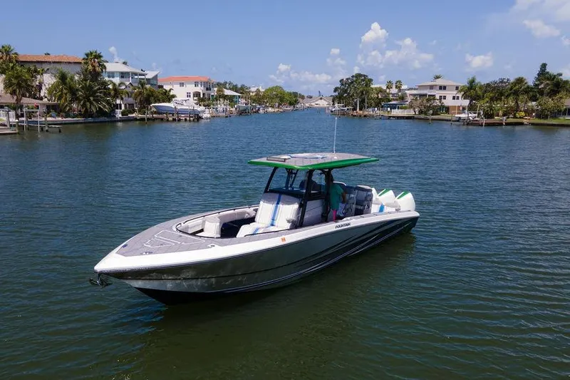  Yacht Photos Pics 2022 Fountain 34 SC boat on a scenic waterway with houses and palm trees.