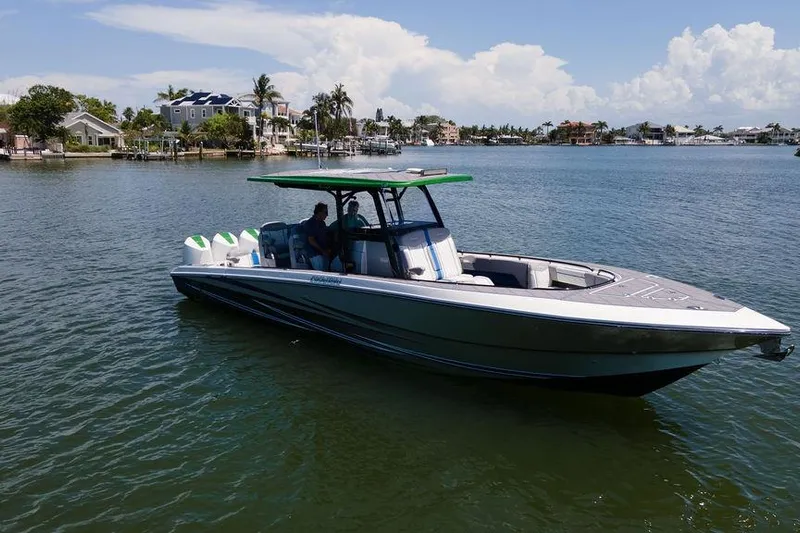  Yacht Photos Pics 2022 Fountain 34 SC boat on calm water with scenic waterfront homes in the background.