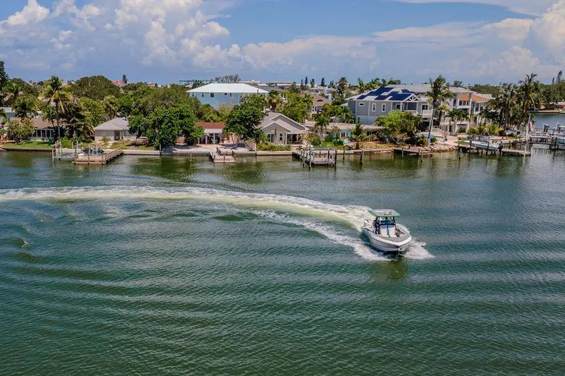  Yacht Photos Pics Aerial view of 2022 Fountain 34 SC boat cruising near waterfront homes.