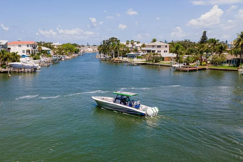 Yacht Photos Pics 2022 Fountain 34 SC boat cruising in a scenic residential waterway.