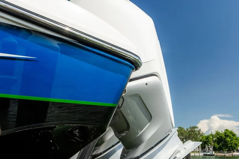  Yacht Photos Pics 2022 Fountain 34 SC boat close-up with blue and green detailing against clear sky.