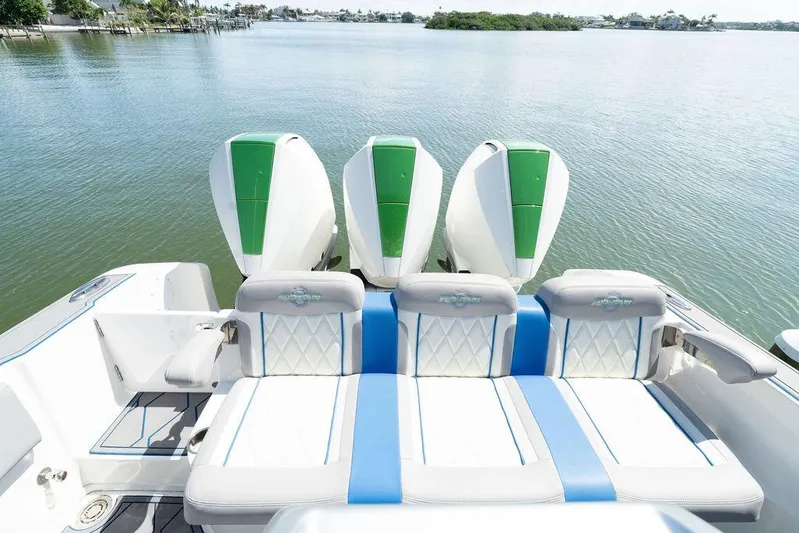  Yacht Photos Pics 2022 Fountain 34 SC boat with triple outboard engines on calm water.