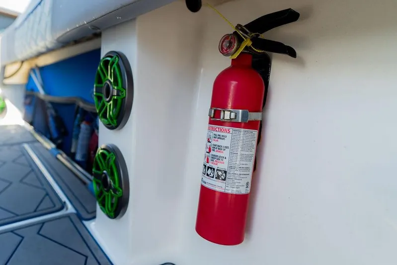  Yacht Photos Pics Fire extinguisher mounted on 2022 Fountain 34 SC boat interior with green speakers.