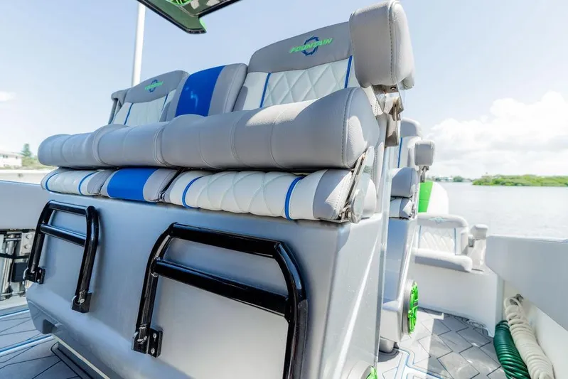  Yacht Photos Pics 2022 Fountain 34 SC boat seats with blue and white upholstery, docked by the water.