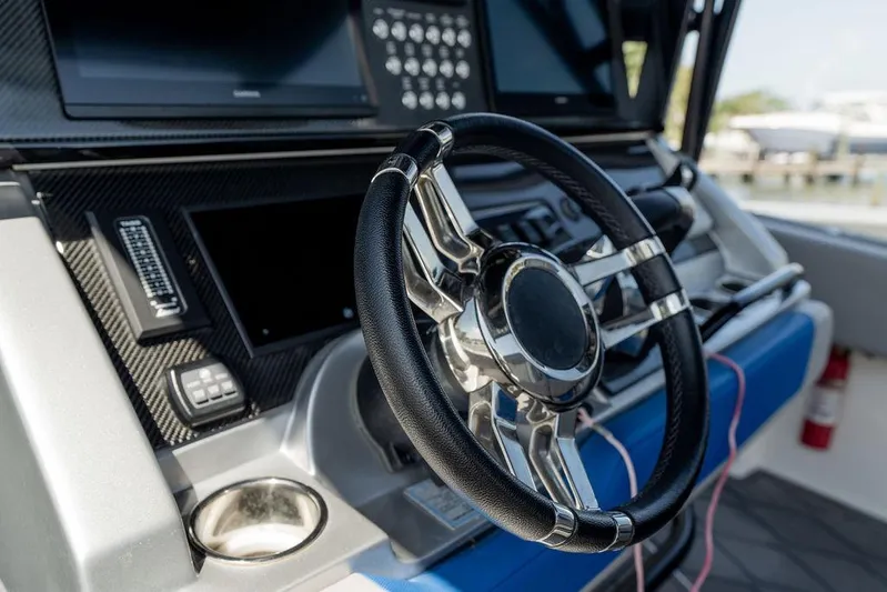  Yacht Photos Pics Steering wheel and dashboard of 2022 Fountain 34 SC boat, featuring modern controls.