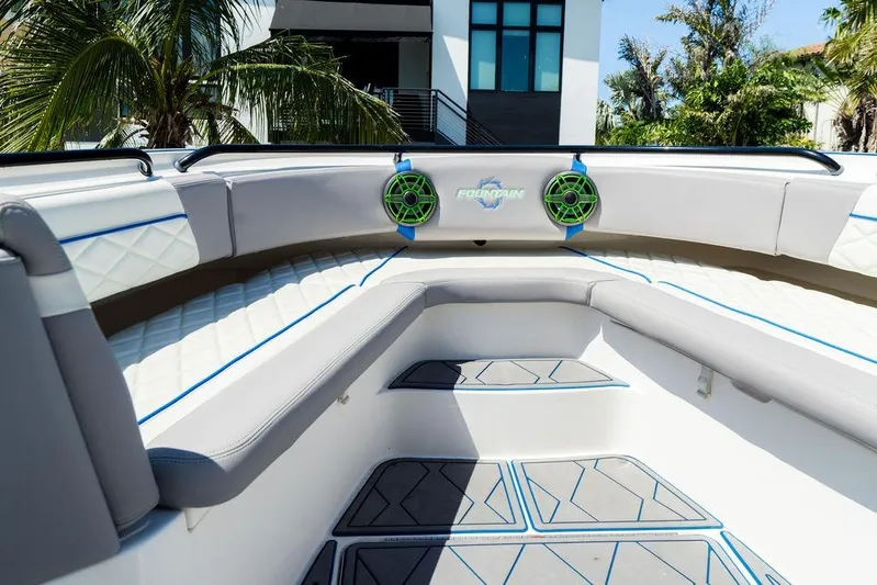  Yacht Photos Pics 2022 Fountain 34 SC boat interior with modern seating and speakers, surrounded by tropical scenery.