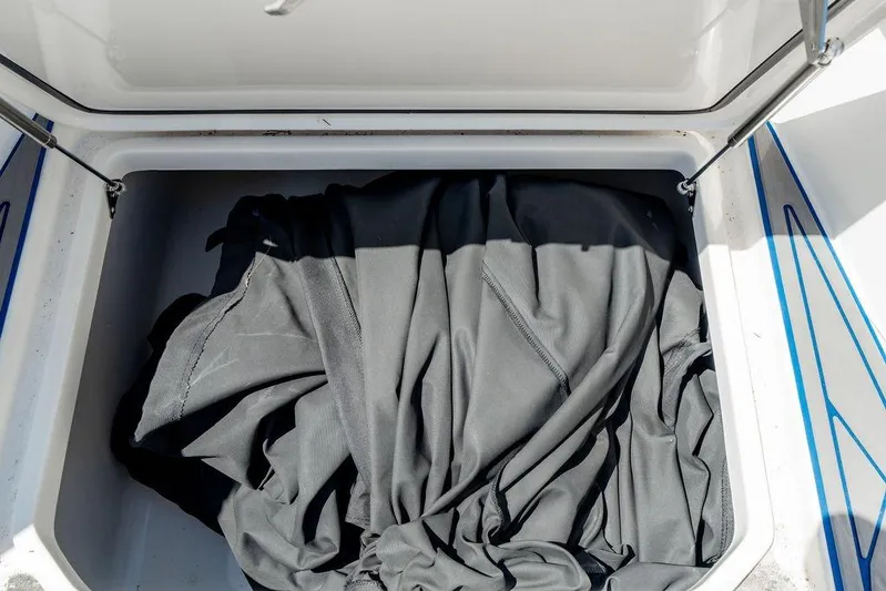  Yacht Photos Pics Open storage compartment on 2022 Fountain 34 SC boat with black fabric inside.