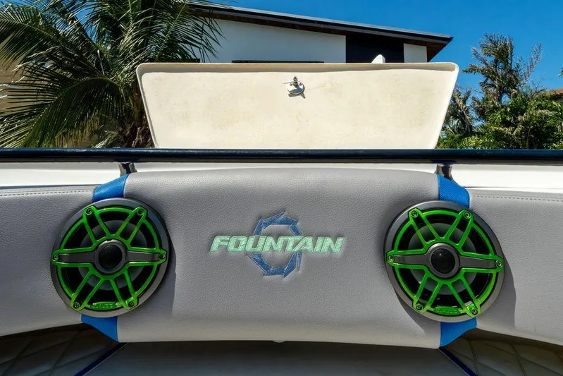  Yacht Photos Pics 2022 Fountain 34 SC boat speakers with green accents and logo, tropical background.