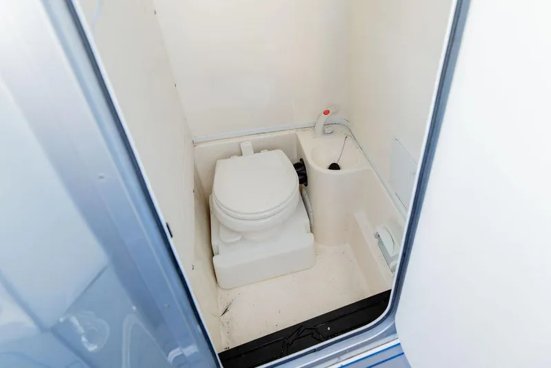  Yacht Photos Pics 2022 Fountain 34 SC boat interior bathroom with compact toilet and sink.
