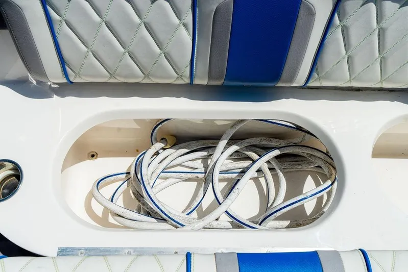  Yacht Photos Pics Coiled rope in storage compartment of 2022 Fountain 34 SC boat with cushioned seating.