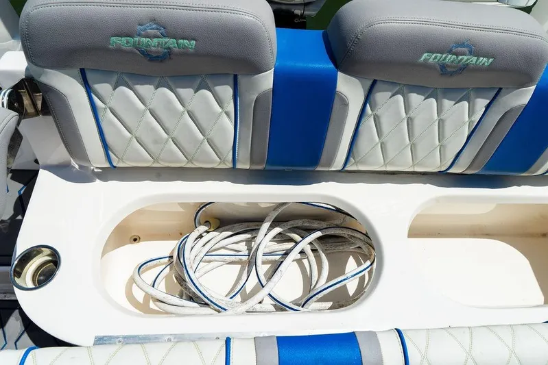  Yacht Photos Pics 2022 Fountain 34 SC boat seating with storage compartment and coiled rope.