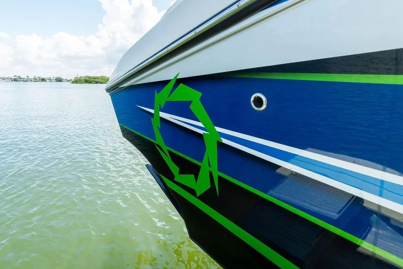  Yacht Photos Pics 2022 Fountain 34 SC boat with blue and green design on calm water.
