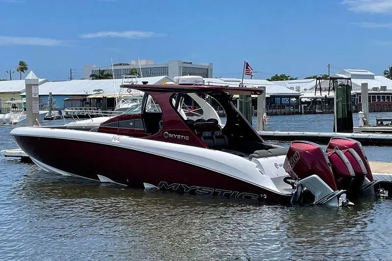  Yacht Photos Pics 2021 Mystic Powerboats M3800 in marina, featuring sleek design and dual outboard engines.