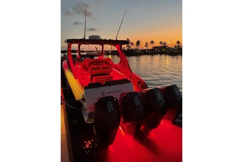  Yacht Photos Pics 2021 Mystic Powerboats M3800 illuminated at sunset with palm trees in the background.