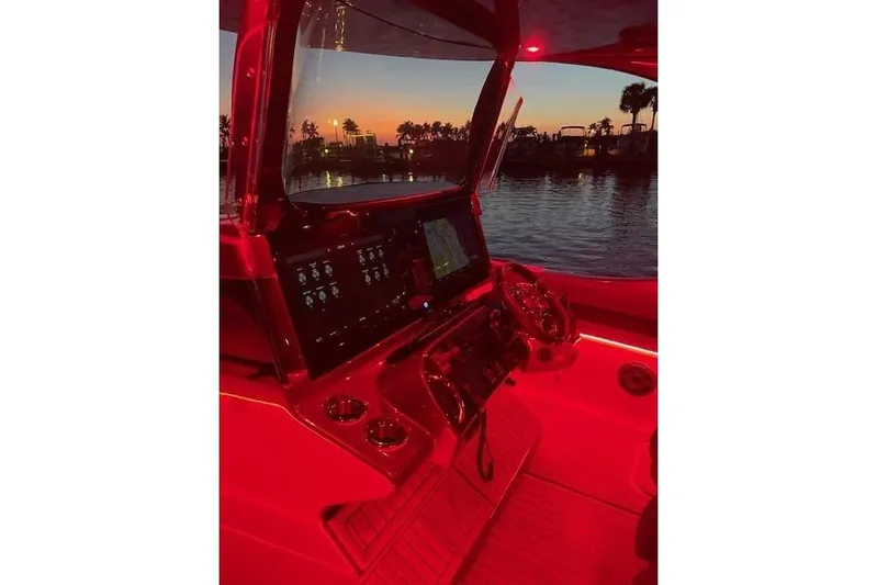  Yacht Photos Pics Cockpit of 2021 Mystic Powerboats M3800 at sunset, illuminated in red.