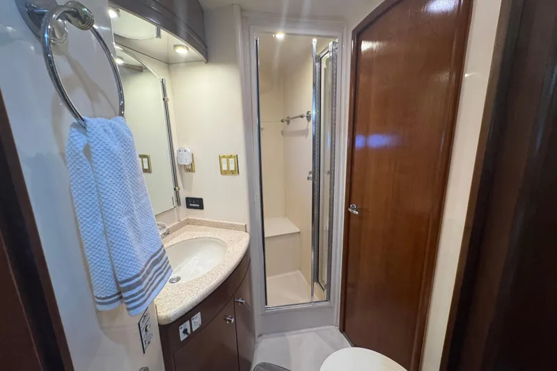 Once Around II Yacht Photos Pics Bathroom interior of 1998 Carver 530 Voyager Pilothouse with sink, shower, and wooden door.