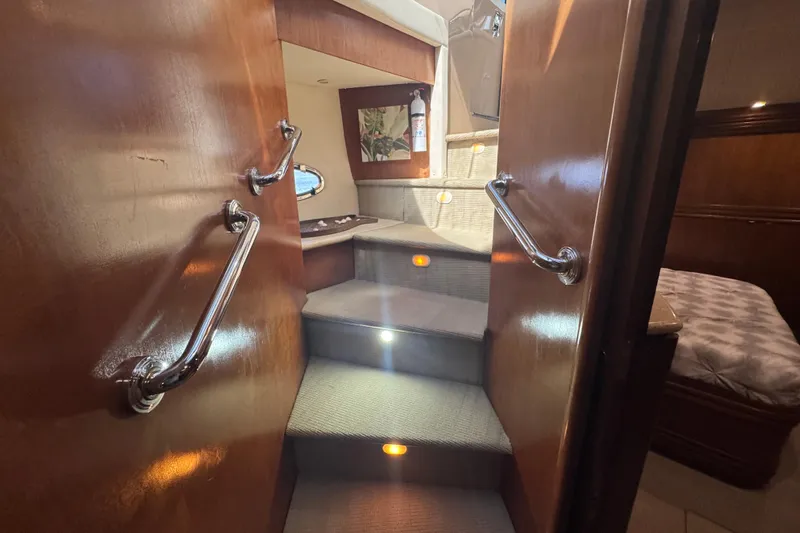 Once Around II Yacht Photos Pics Interior stairs of 1998 Carver 530 Voyager Pilothouse with wooden handrails and ambient lighting.