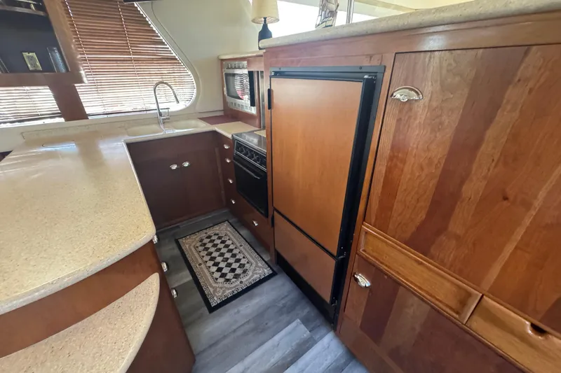 Once Around II Yacht Photos Pics 1998 Carver 530 Voyager Pilothouse kitchen with wood cabinetry and modern appliances.