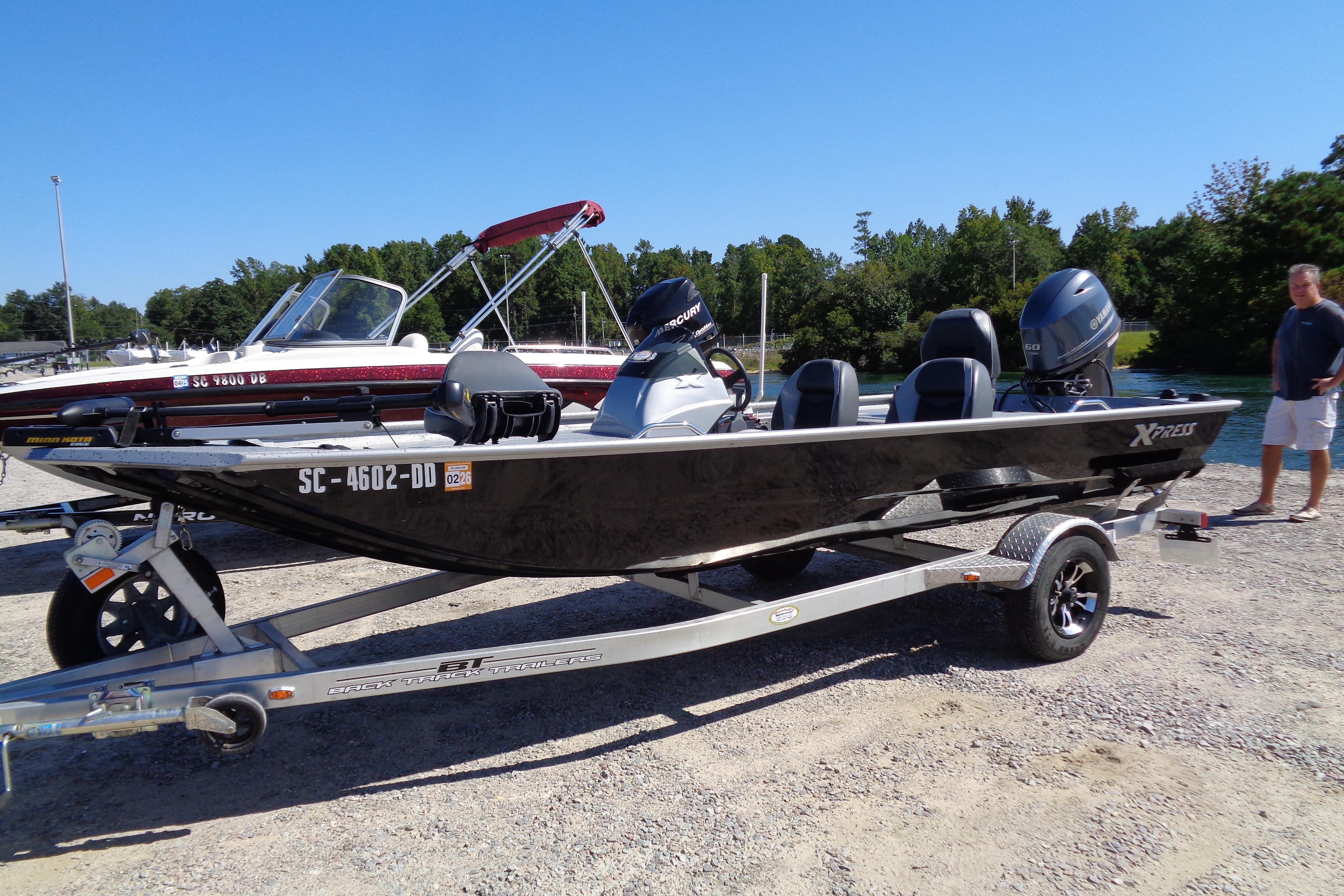 2016 Express PT175 boat on trailer, parked near water, with outboard motor.