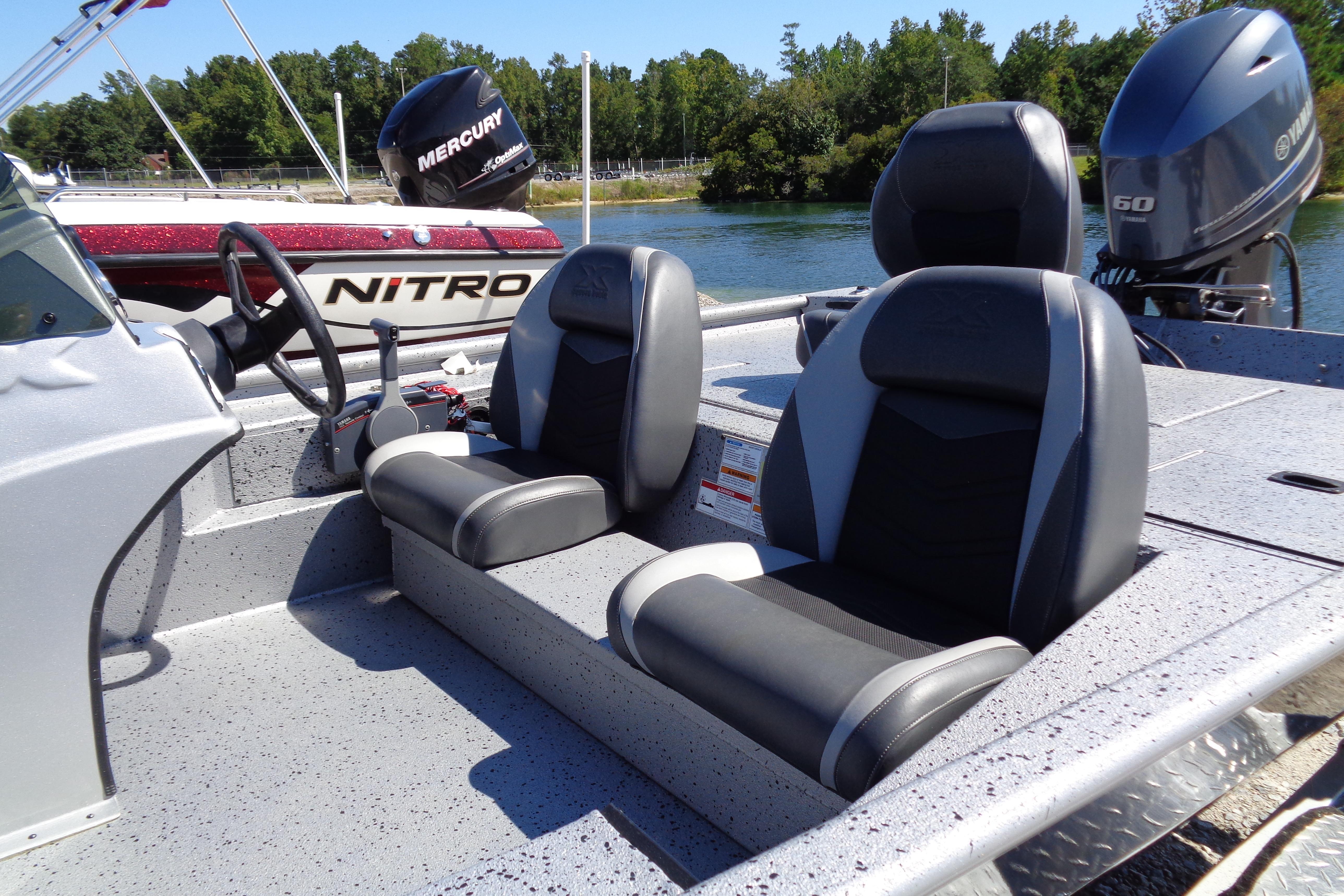 2016 Express PT175 boat interior with dual seats and steering wheel, docked by the water.
