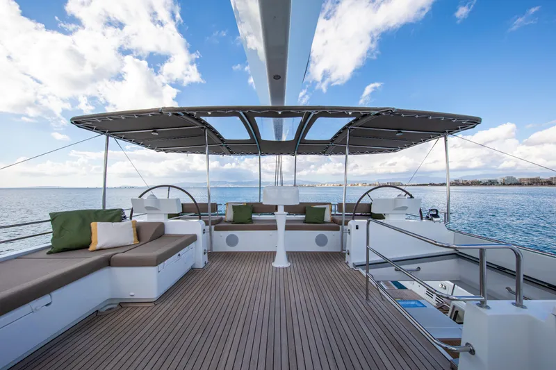  Yacht Photos Pics Luxurious 2024 Lagoon 620 NEO yacht deck with seating, ocean view, and canopy.