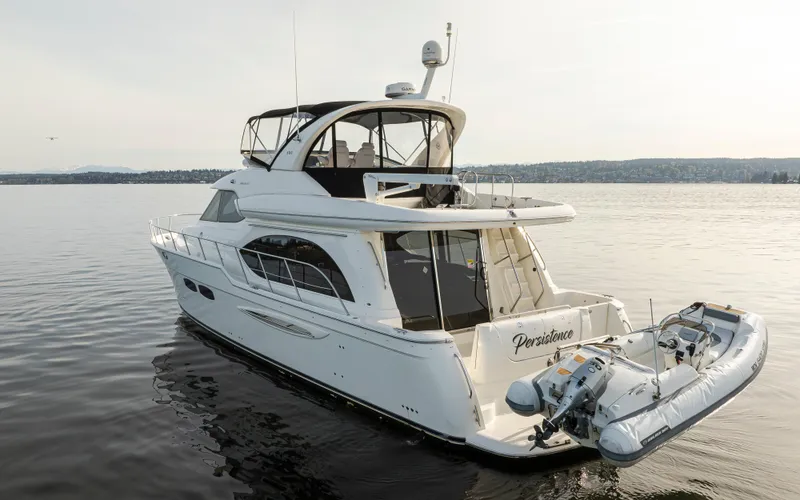 Persistence Yacht Photos Pics 2010 Meridian 580 Pilothouse yacht on calm water with inflatable boat attached.