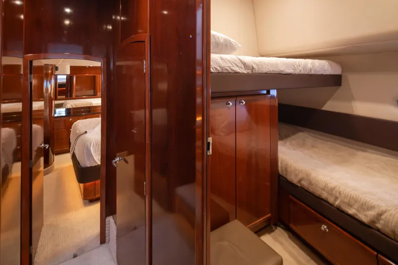 Persistence Yacht Photos Pics Luxurious interior of 2010 Meridian 580 Pilothouse with cozy bunk beds and wooden cabinetry.
